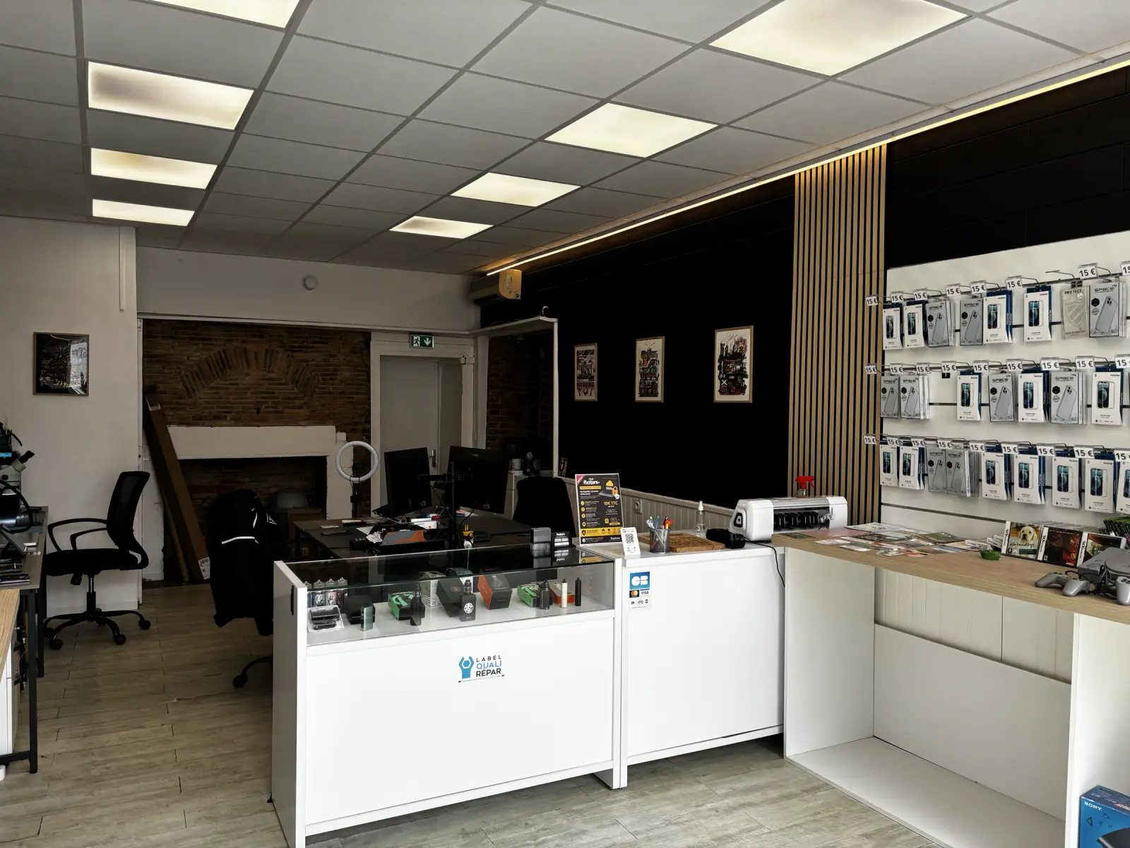 Vue générale du nouvel intérieur de Fixstore avec son mur noir, ses tasseaux de bois et son comptoir