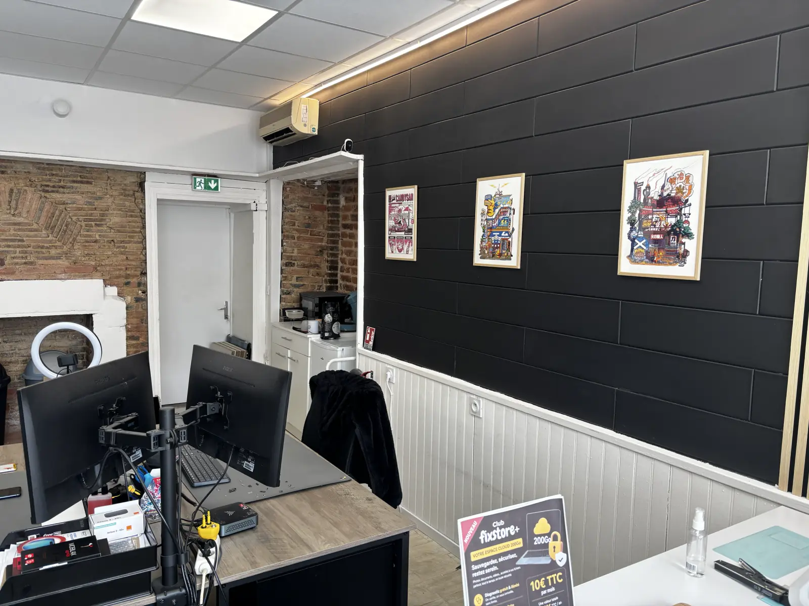 Décoration murale du magasin Fixstore avec cadres sur un mur noir