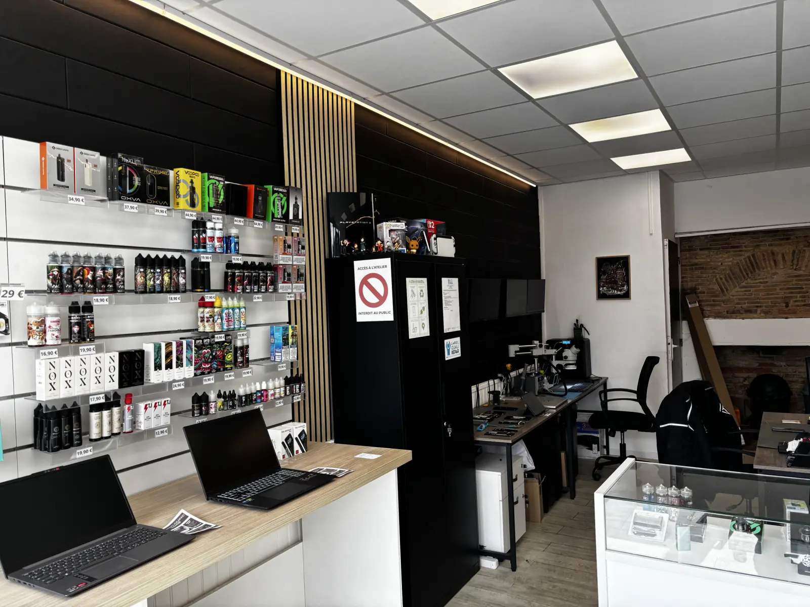 Nouvel espace de vente Fixstore avec mur noir, tasseaux de bois et éclairage chaud